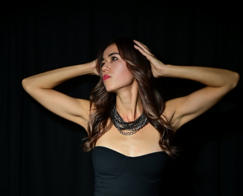 Bold portrait of a young lady with hands on her head